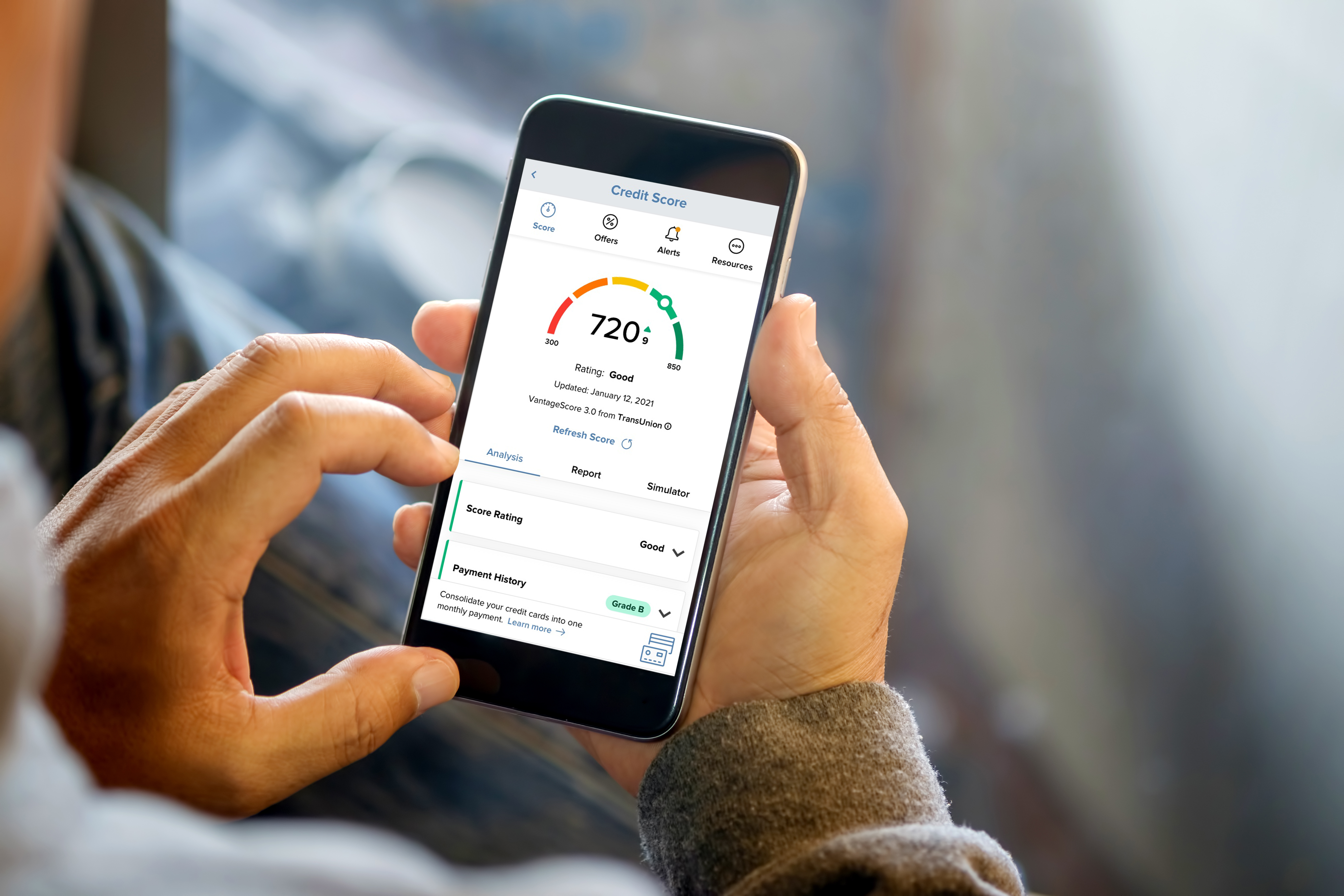Hands holding a mobile phone with the credit score page on the screen