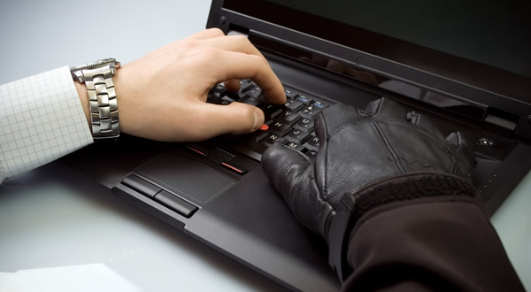 hands on laptop one with a black glove